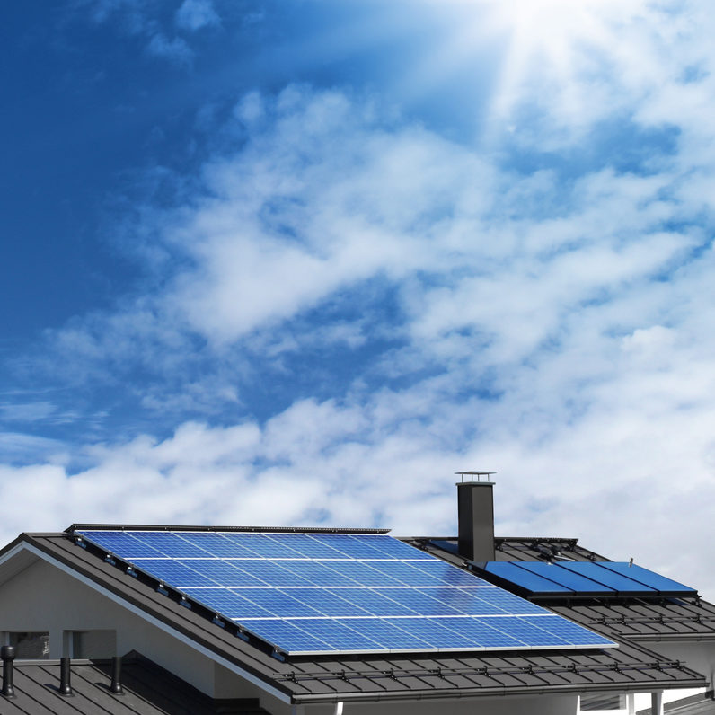 Solar panel system on house roof, sunny blue sky background